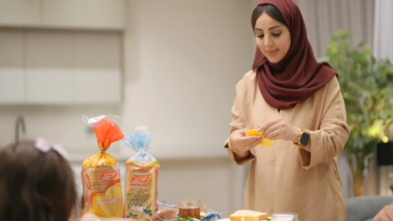 A mother serving breakfast with Fonte bread at a family table